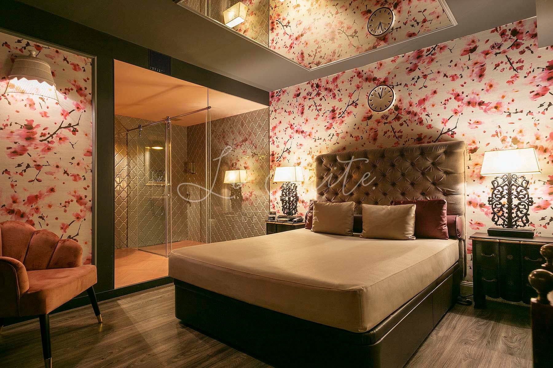 Camera Sensualità, pareti rosa, con pavimento in legno e arredata a La Suite, Barcellona