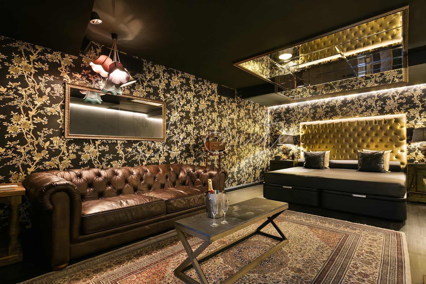 Suite Lujuria, decorated in gold and wood finishes, furnished with the highest quality at La Suite, Barcelona