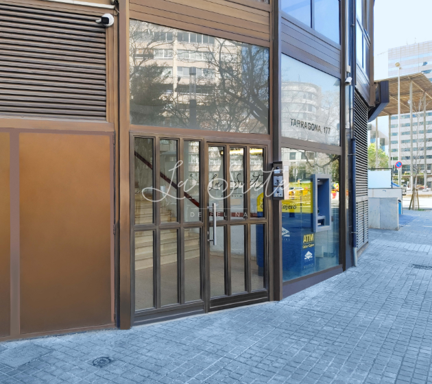 Aluminium and glass main door of the facade of the brothel La Suite Barcelona visible from the street Tarragona 177. | Las Suite BCN